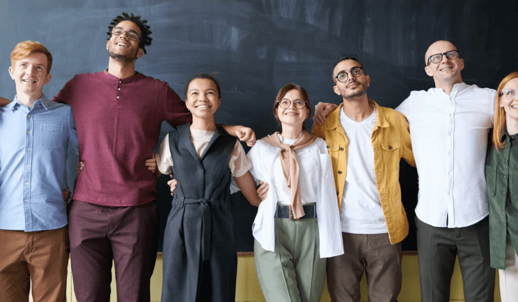 Group of people standing together in a line in front of chalk board