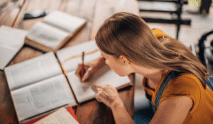 Women sitting at a desk looking at text books taking notes